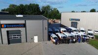 Das Team von EB vor dem Firmengebäude und den Unternehmensfahrzeugen