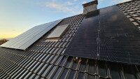 Neue Solaranlagen auf Dach vor sonnigem Abendhimmel