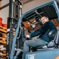 Mann im Gabelstapler schaut in Kamera